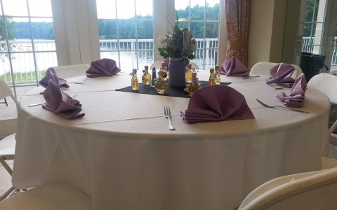 banquet table with purple napkins near window overlooking river