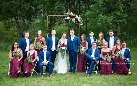 bridesmaids and groomsmen standing beside bride and groom outside