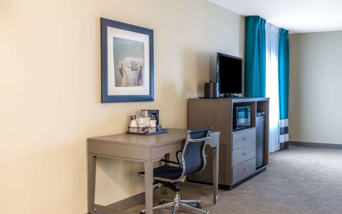desk and chair in suite with tv