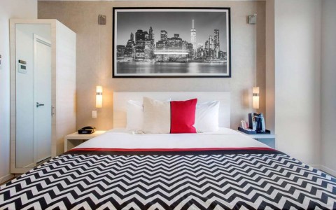 king bed with picture of skyline hanging over it