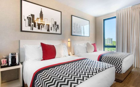 Guest room with two double beds, coffee maker, and large window