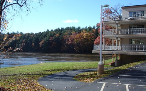 view of hotel balconies and river during fall time with orange and red leaves