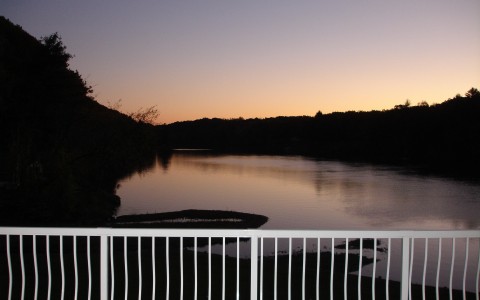 view of river and surrounding trees during sunset