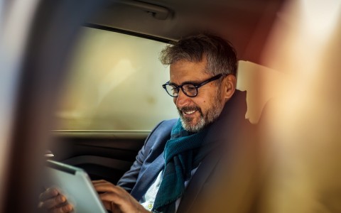 man in car looking at tablet