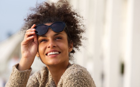 woman looking out holding sunglasses on her head
