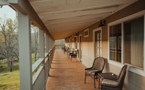 porch with the sun shining on it with chairs and tables