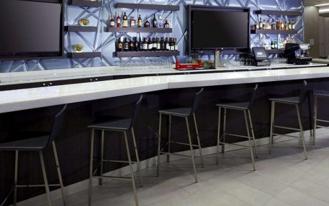 modern cocktail bar with seating and televisions