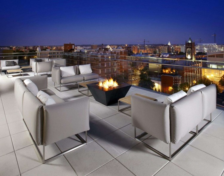 hotel rooftop with seating and fire pit with view of city