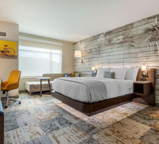 Guest room with one bed, work desk, and flat screen