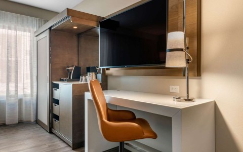 Guest room with orange chair and work desk