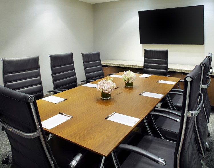 boardroom with table and chairs and a tv on the wall