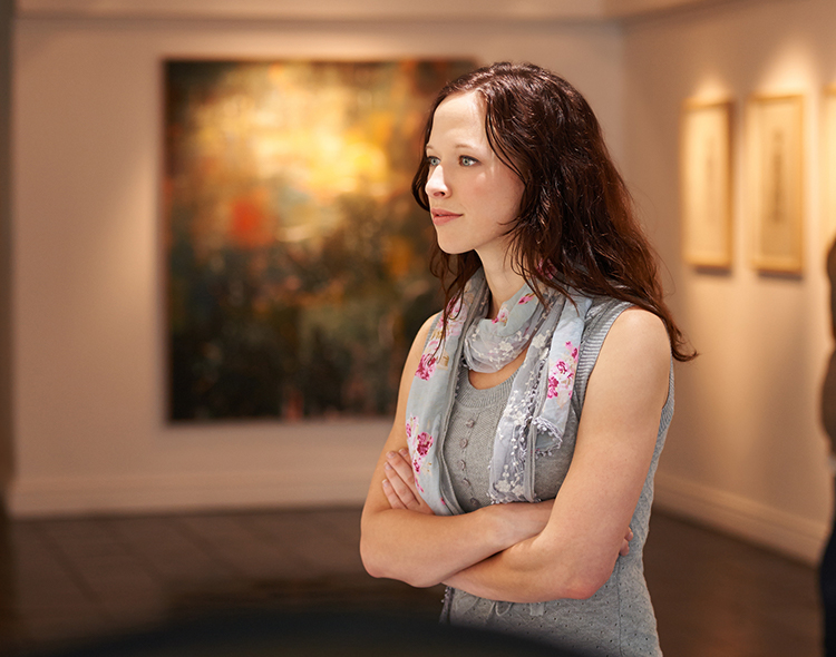 woman observing art in museum