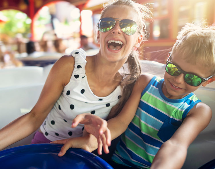 kids smiling on ride in amusement park