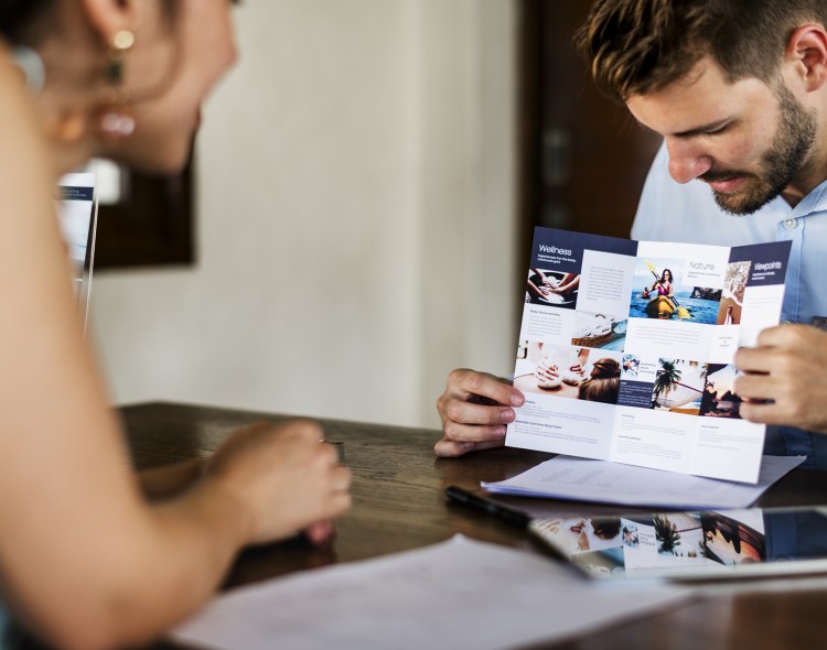 man showing pamphlet presentation to woman