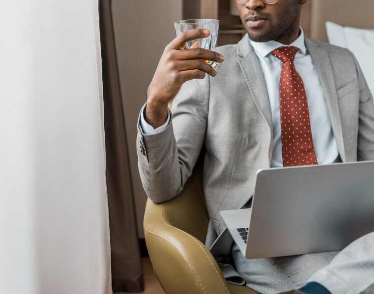 businessperson in suit sitting with a drink