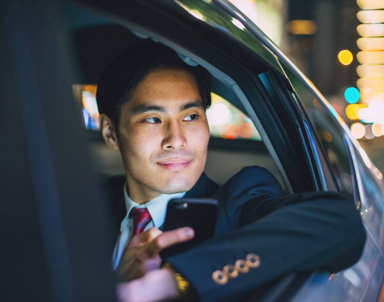 man in suit looking out car window