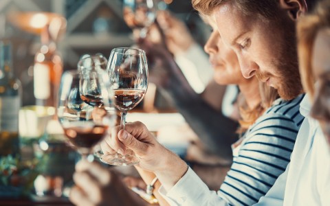 people holding wine glasses up 