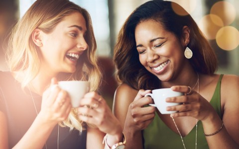 two friends having coffee and smiling