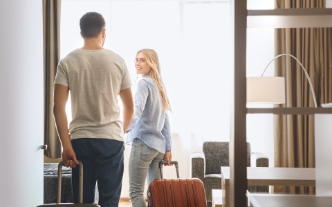 couple walking into suite with luggage