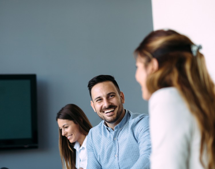 group of three people at meeting table talking