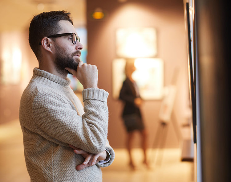 man looking at an art gallery