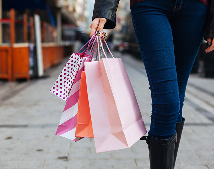 a woman carrying multiple shopping bags in the streets