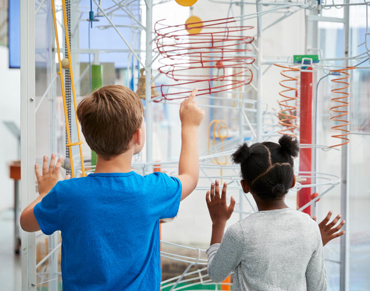 kids looking at ball track in museum