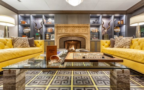 lobby with yellow sofas, fireplace, and game of scrabble on table