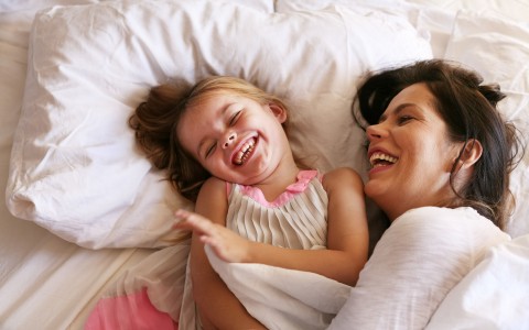 mom and daughter snuggled up together laughing