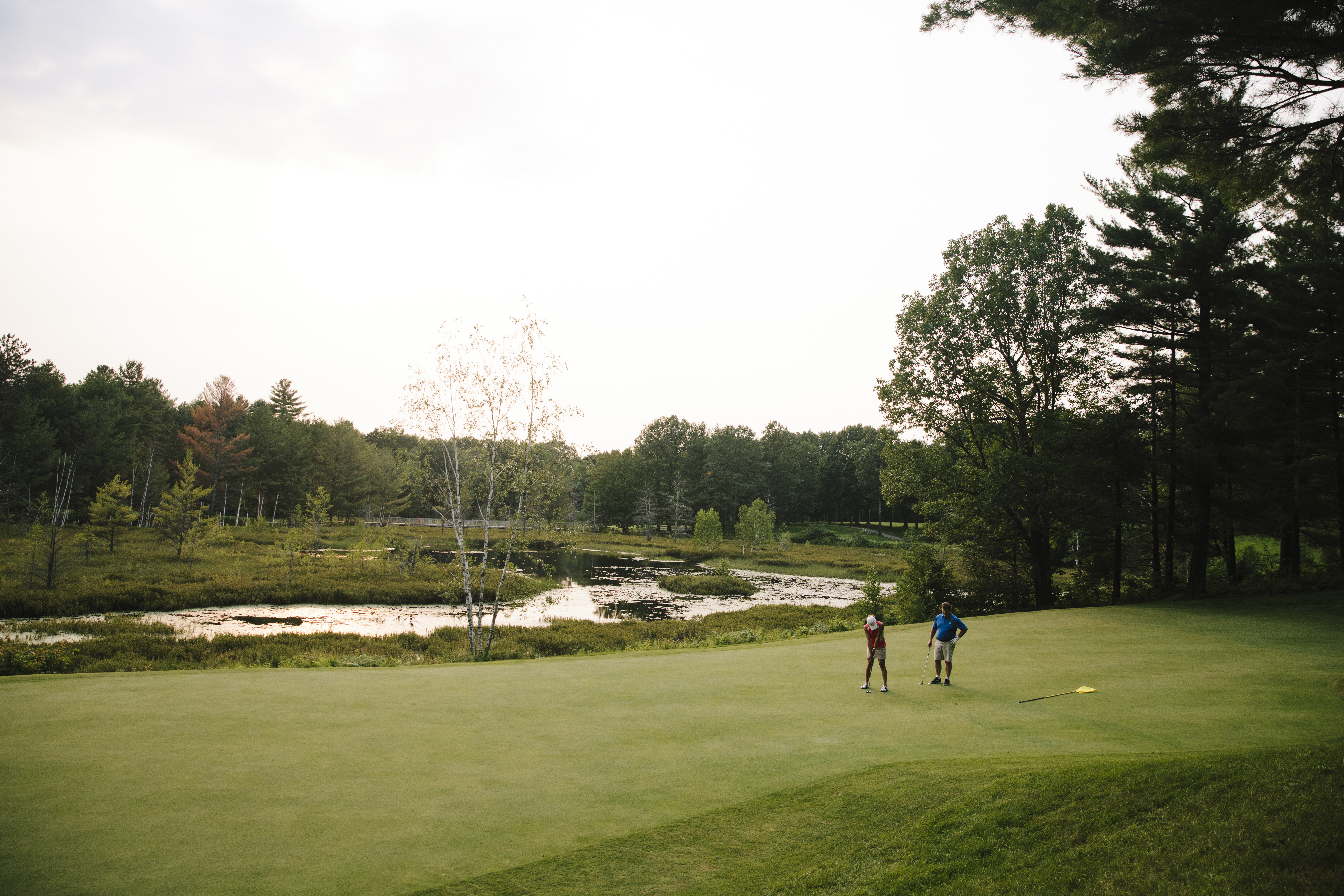 2 people playing golf on green