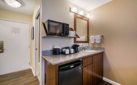 kitchenette area with mini fridge, coffee maker, microwave, and sink