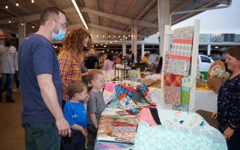 family looking at a booth with cloths