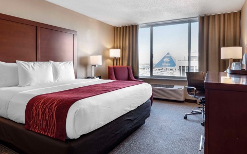 king size bed in room with a large window with a view of memphis 