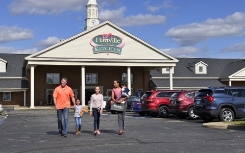 family leaving a store on a sunny day
