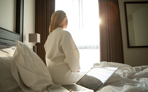 woman in white robe sitting in bed