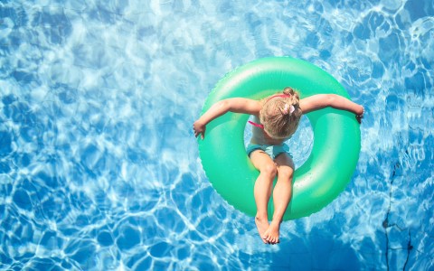 person sitting in green tube in pool