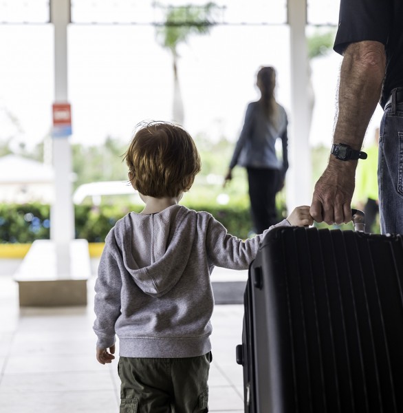 little boy and his dad pulling a large suitcase