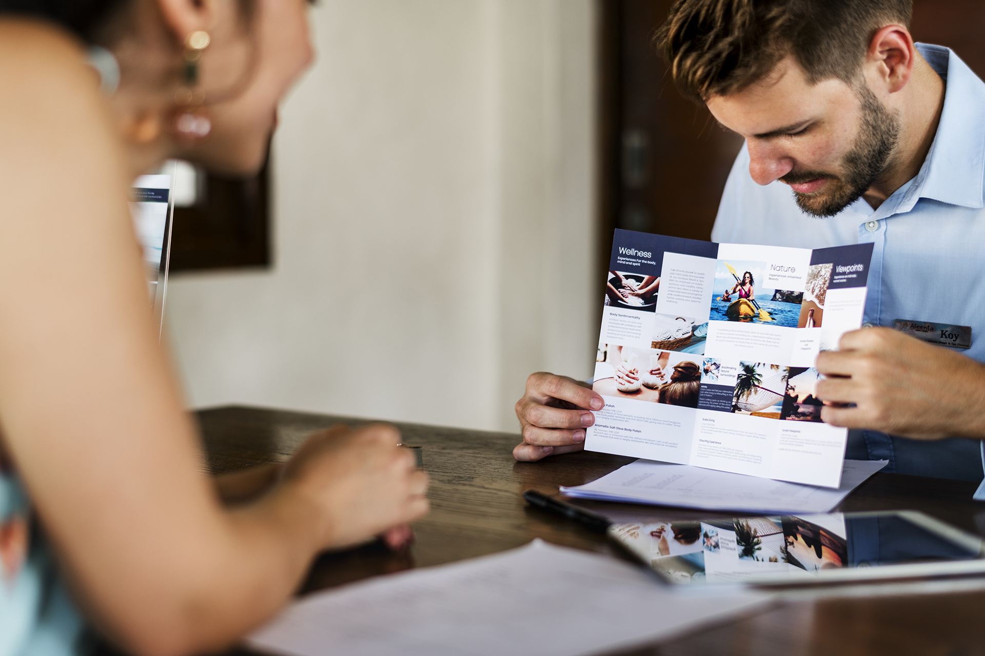 man presenting pamphlet to woman