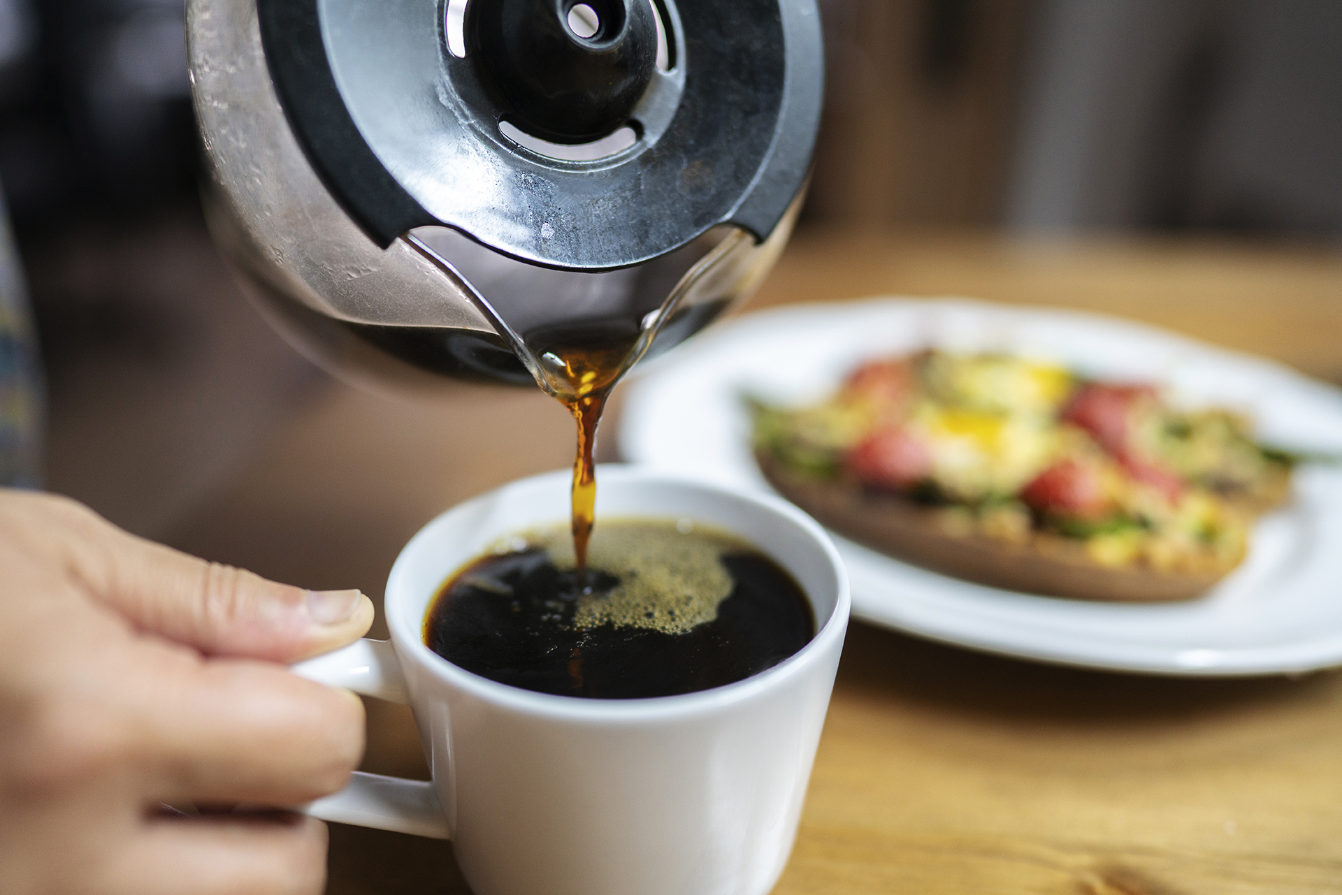 coffee being poured into a mug from a pot