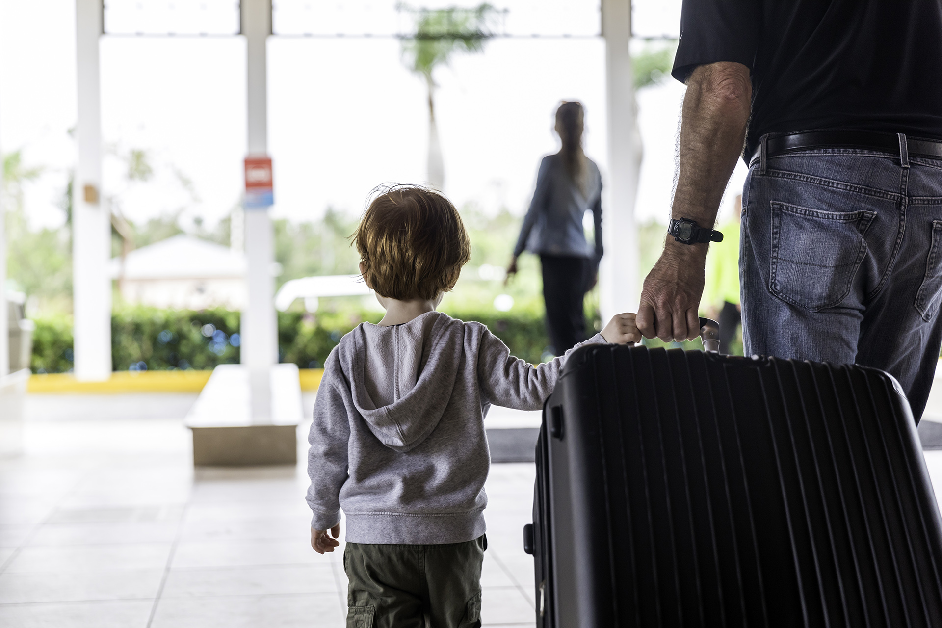little boy and his dad pulling a large suitcase