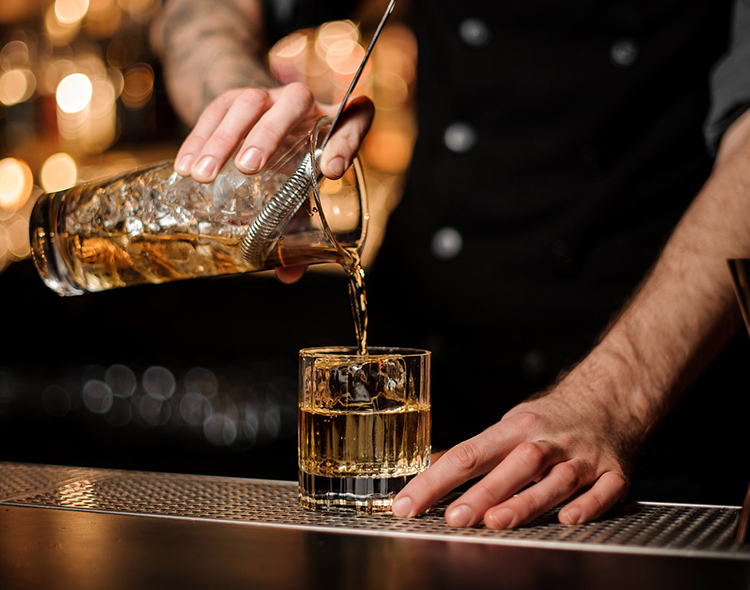 bartender pouring a glass of whisky