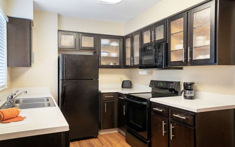 kitchen in suite with fridge, counters, sink, cabinets and microwave
