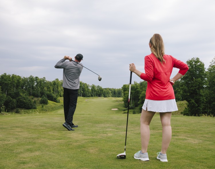 man and woman playing golf on course