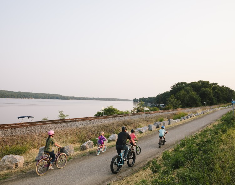 family biking next to lake