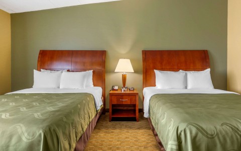 room with two queen beds with green sheets