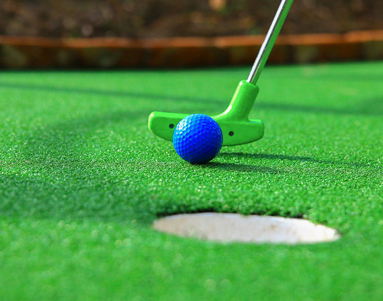 mini golf put about to hit blue golf ball
