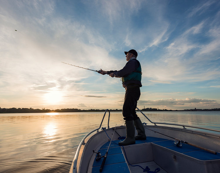 man in boat fishing on lake