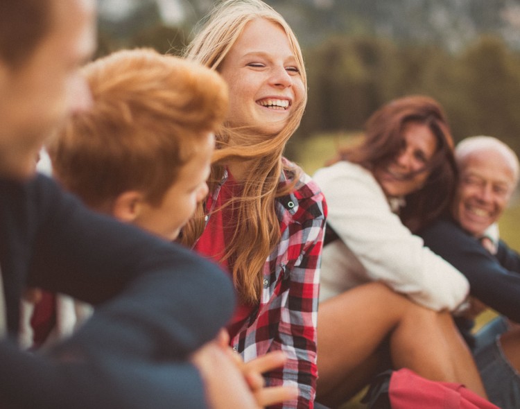 children with their family smiling together outside