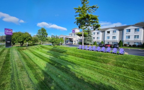 wide shot of exterior of hotel with purple chairs in front