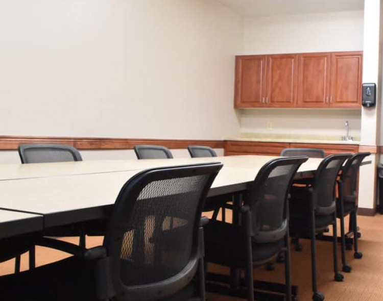 boardroom with long table and black chairs